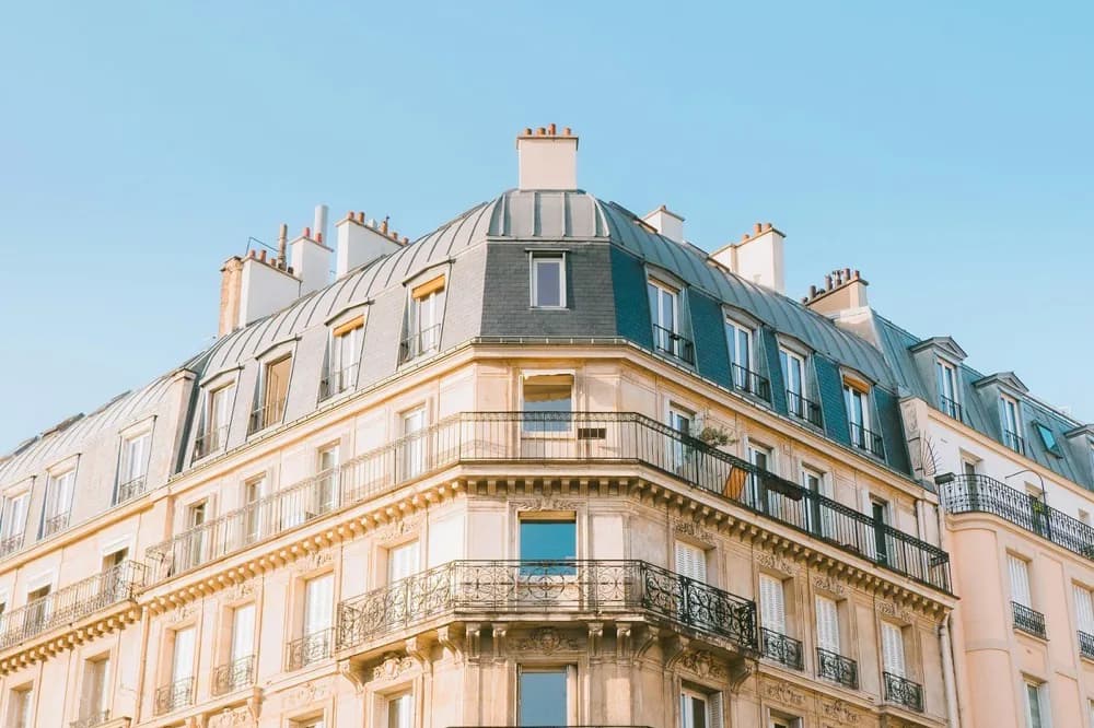 Angle d'un immeuble ancien, balcons de fer forgé et toiture en zinc