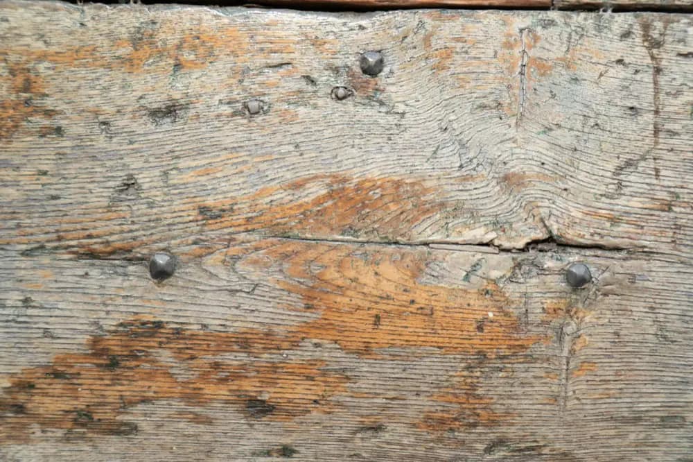 Poutre de bois ancienne, fendue, clouée, marquée par le temps