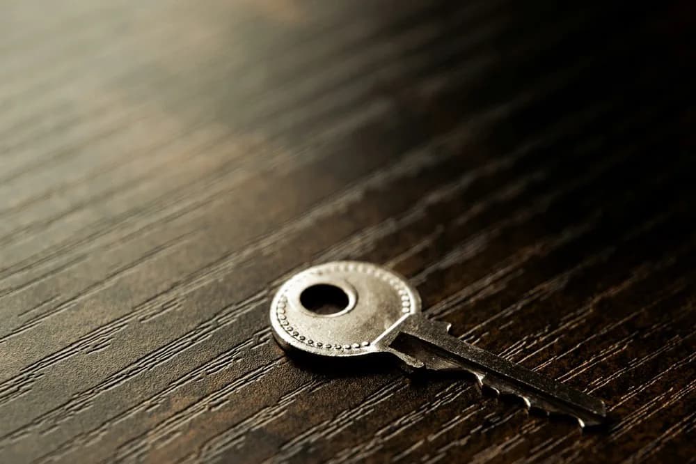 Clé ancienne posée seule sur un plateau de bois sombre